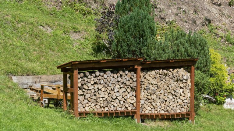 Gespaltene Holzscheite in einem überdachten Holzunterstand mit Abstand zum Boden