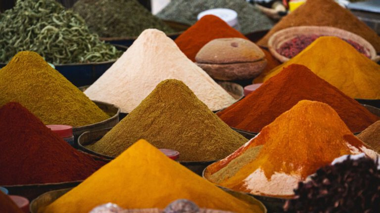 Kegelförmig aufgeschüttete bunte Gewürzpulver auf einem Markt