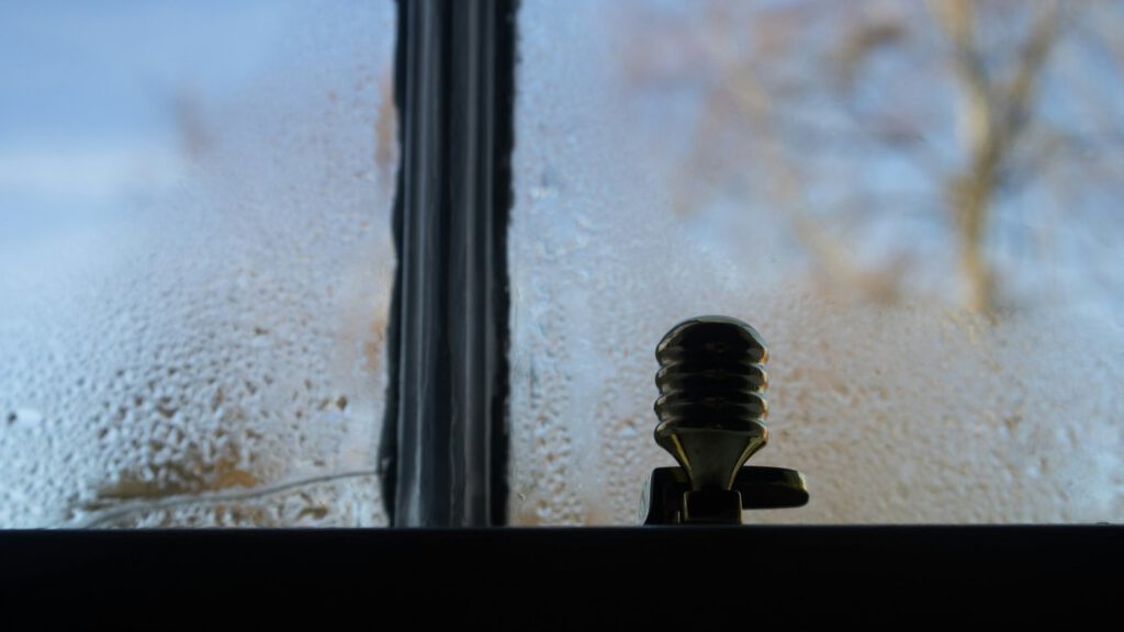 Von innen beschlagene Fensterscheibe mit Wassertropfen