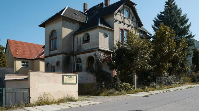 Älteres Wohnhaus mit Erker und Türmchen an einer Straße